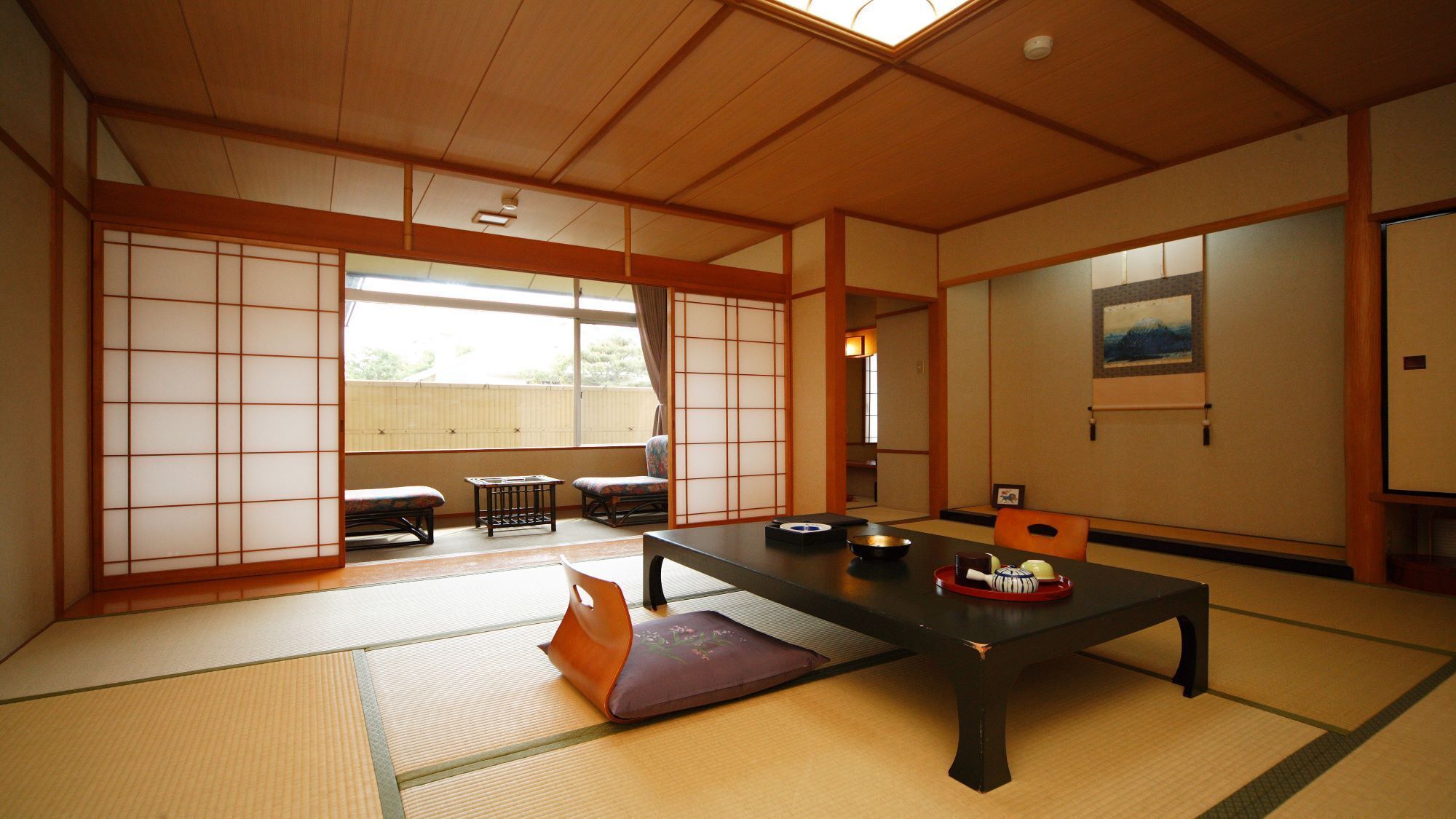 Una tradizionale stanza giapponese con pavimento in tatami, un tavolino basso e porte scorrevoli.