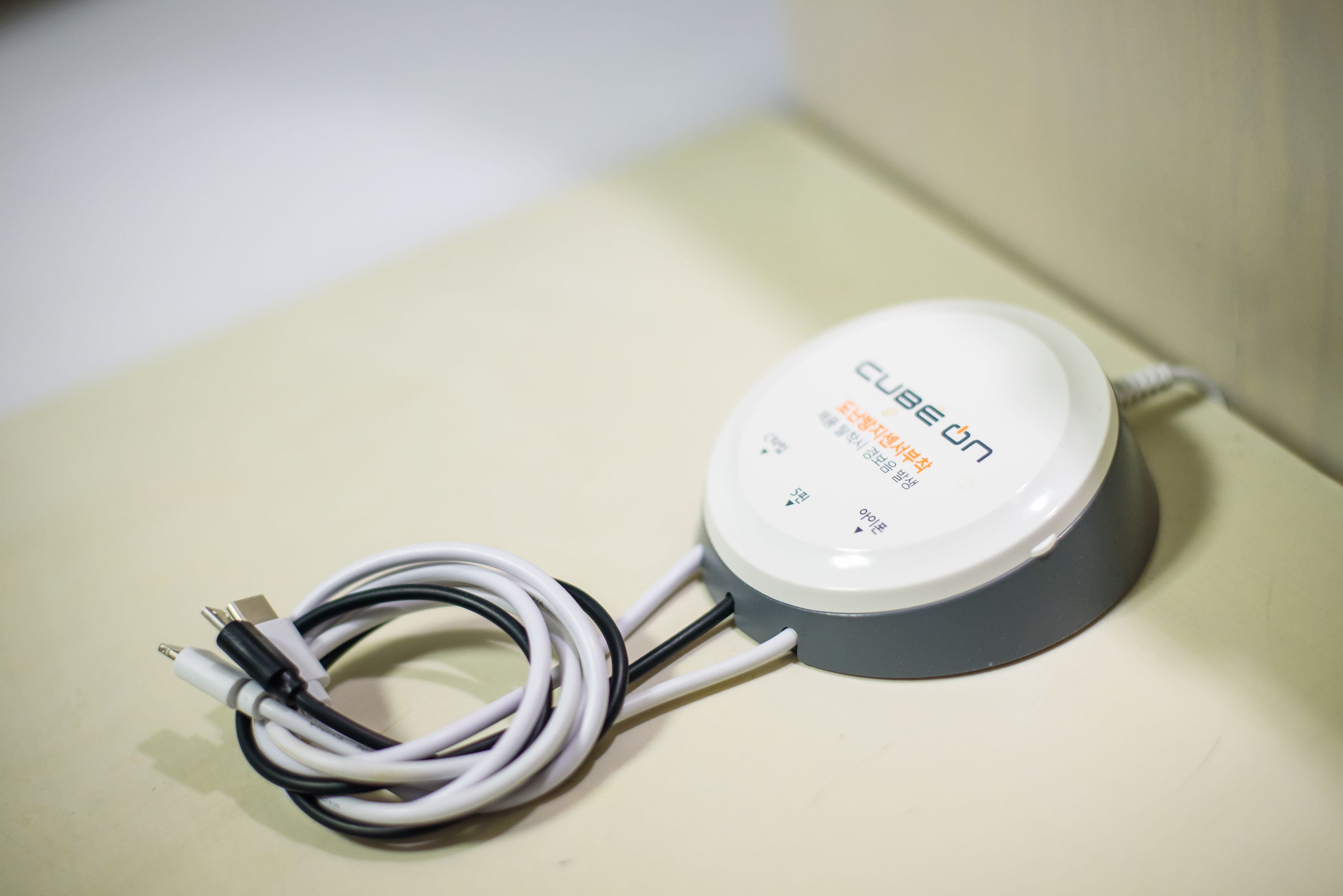 Un dispositivo CUBE ON con un cable y un cable de alimentación.