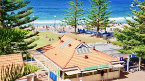 Um resort à beira-mar com um quiosque chamado 'Goose & Kiosk', área de estar ao ar livre e vista para o oceano.