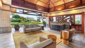 A spacious lobby with a high ceiling, a reception desk, seating area, and a view of greenery outside. - Discover Ko Olina: Exclusive Deals on Your Dream Vacation in Our 2BR Condo (Kapolei)