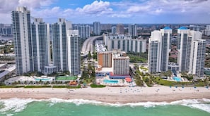 A coastal cityscape with high-rise buildings, a beach, and a marina. - Beautiful Hotel Studio on the beach. STR-01535 (Sunny Isles Beach)