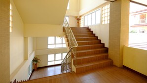 A staircase with wooden steps and metal railings, leading to an upper floor. - The Muk Lagoon (Mukdahan)