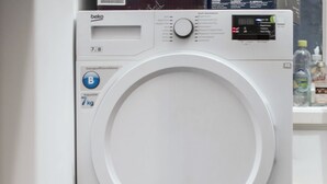 Zwei übereinandergestellte Waschmaschinen in einem Waschraum.