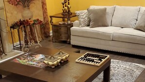 Ein Wohnzimmer mit Sofa, Couchtisch, Teppich und einem Gemälde.