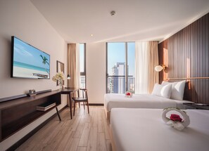 Una habitación de hotel con cama, escritorio, televisor y vistas a la ciudad.