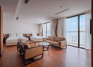 Una habitación de hotel con cama, sofá, sillón y una mesa.