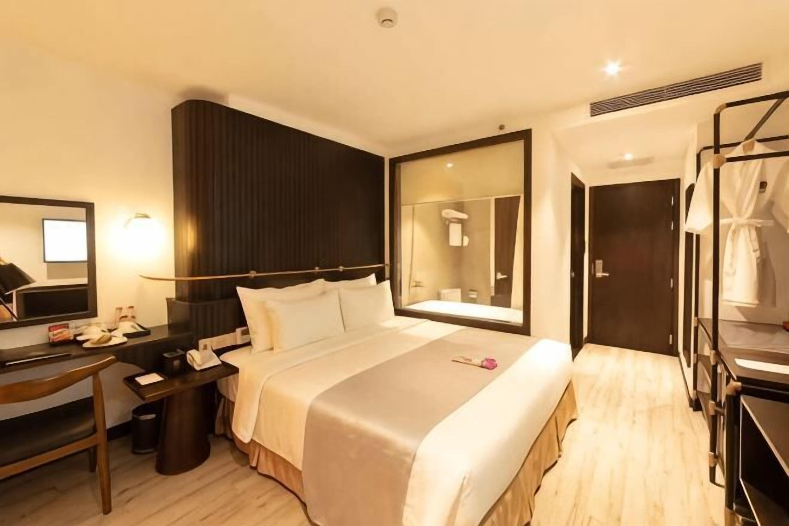 Ein Hotelzimmer mit Bett, Schreibtisch, Spiegel und Stockbetten.