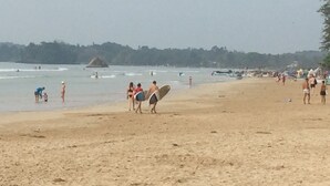 A beach with people walking and some carrying surfboards. - Weligama Ocean Breeze (Weligama)