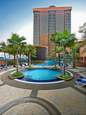 A hotel with a large pool surrounded by palm trees and lounge chairs. - Grand Service Apartment at Times Square (Kuala Lumpur)