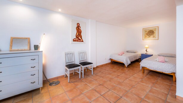 A bedroom with two beds, a dresser, chairs, and artwork on the walls. - GREAT VILLA WITH PRIVATE POOL, CLOSE TO THE BEACH, FULLY EQUIPED. (SA COMA, SANT LLORENC, MALLORCA, BALEARES)