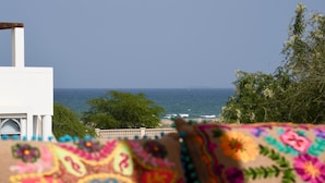Une vue sur la mer depuis un balcon, avec un tissu à motifs au premier plan.