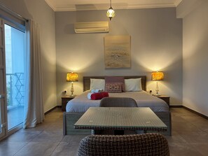 Relax in comfort with a large bed, bedside tables, and a glass-top table.