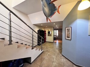 Staircase and artwork adorn this stylish space, featuring a large fish decoration and a water dispenser.