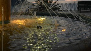 A fountain with water jets, a lamp post, and a bench in the background. - Michelangelo House, mono (Gioiosa Marea)