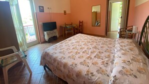 A bedroom with a bed, a desk, a chair, and a television. - Michelangelo House, mono (Gioiosa Marea)