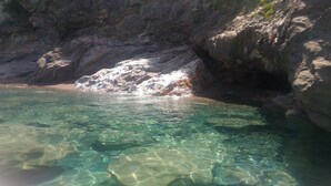 A rocky shoreline with clear water and a cave entrance. - Michelangelo House, mono (Gioiosa Marea)