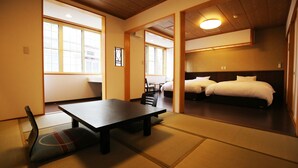 A traditional Japanese room with tatami flooring, a low table, and a futon bed. - Nakajimaya Ryokan (Nozawaonsen)