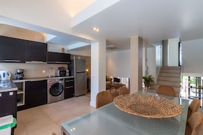Enjoy a compact yet functional stay with a kitchenette, dining area, and living space featuring a sofa and staircase to an upper level.