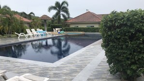 A swimming pool with lounge chairs and a small hot tub. - Nice Villa in Hua Hin (Hua Hin)