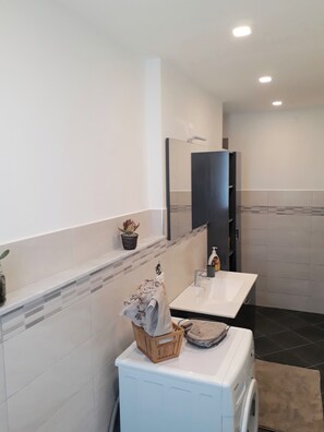 Een bad/douchecombinatie, handdoeken