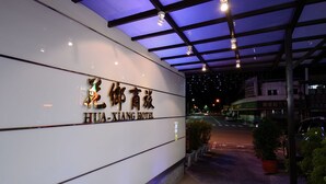 The exterior of Hualuxiang Hotel with a modern design, featuring a prominent sign and a covered entrance area. - Huaxiang Hotel - Zuoying (Kaohsiung)