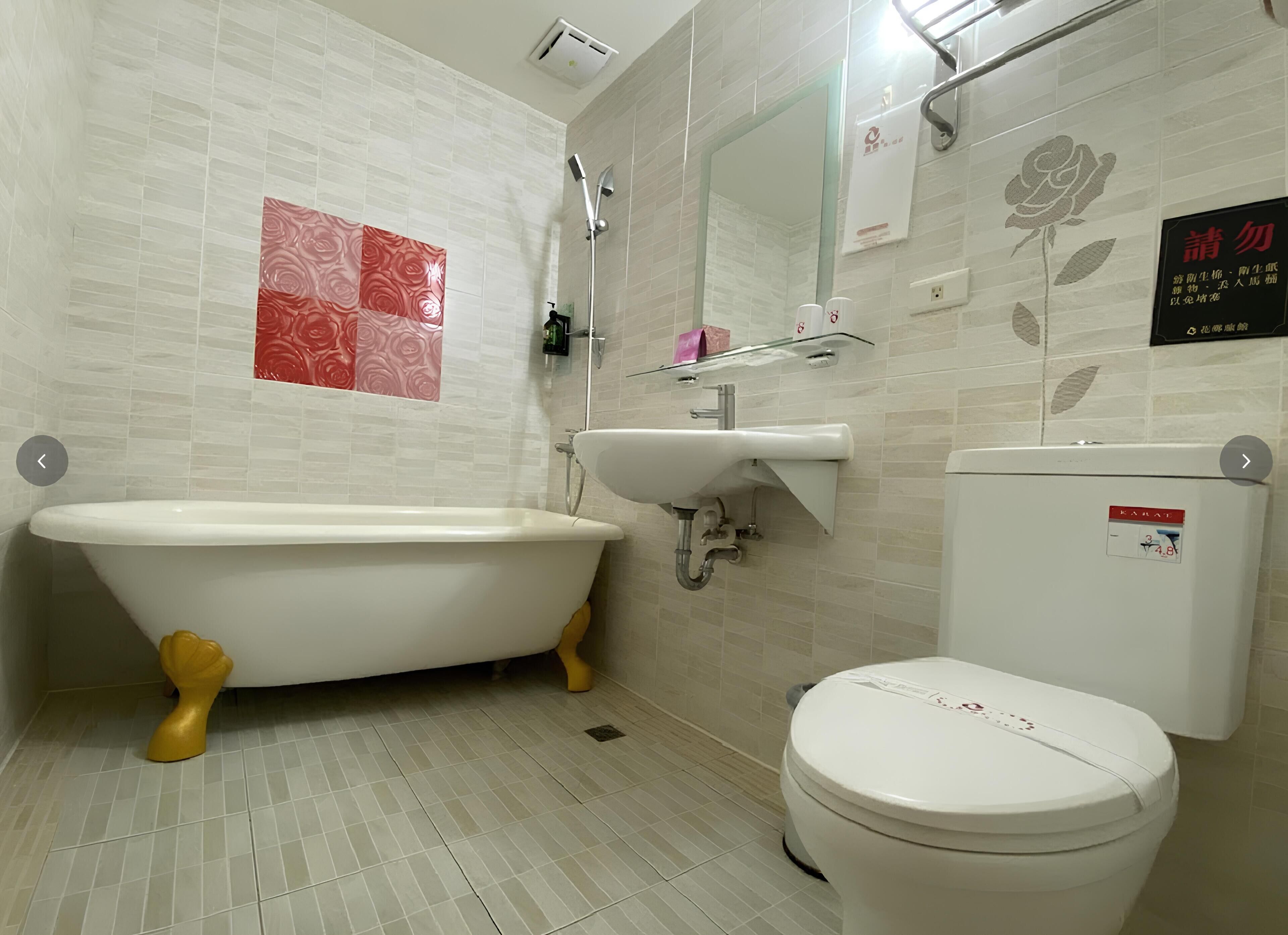 Ein Badezimmer mit einer Badewanne auf Füßen, einem Waschbecken und einer Toilette.