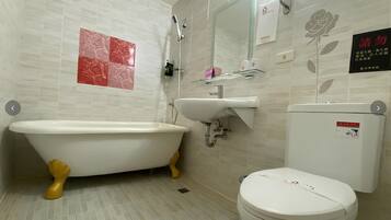 Un baño con bañera de patas de león, lavamanos y retrete.