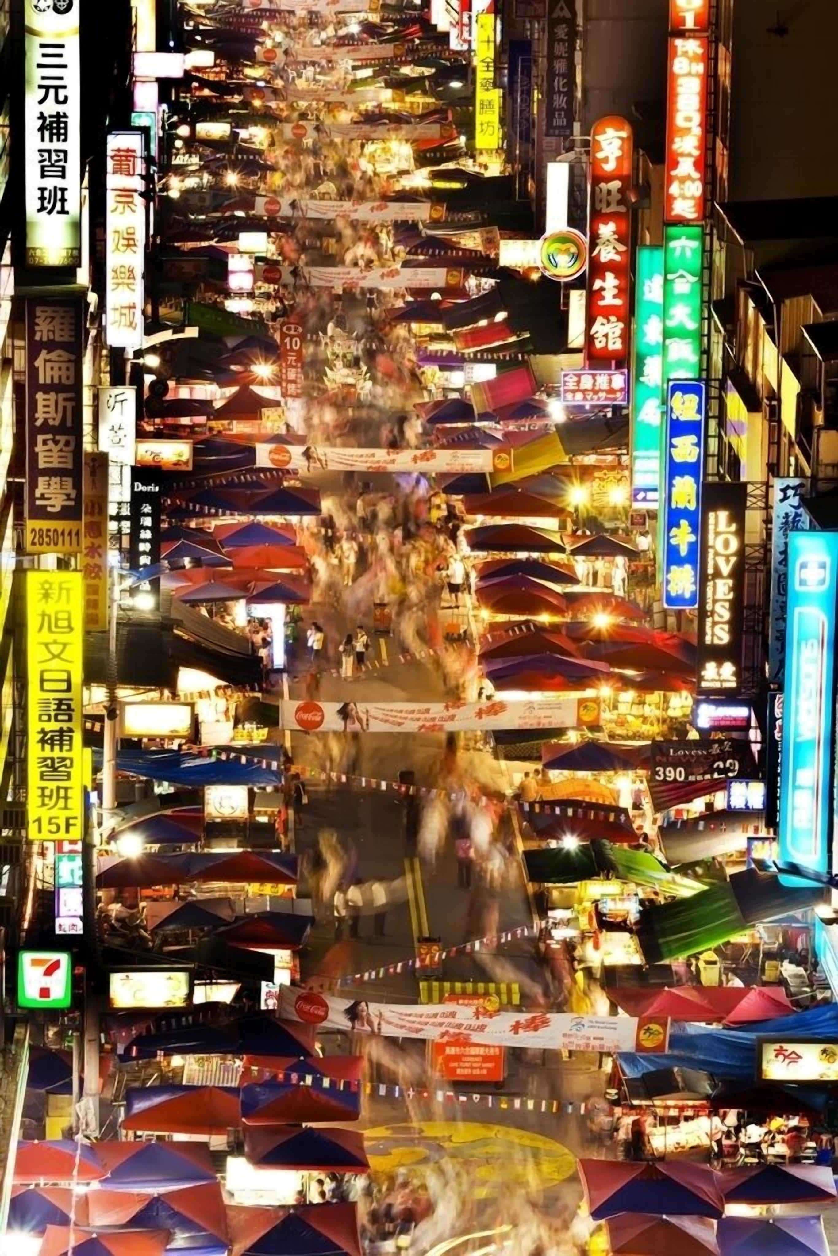 A bustling street scene with numerous shops and signs, indicating a lively commercial area.