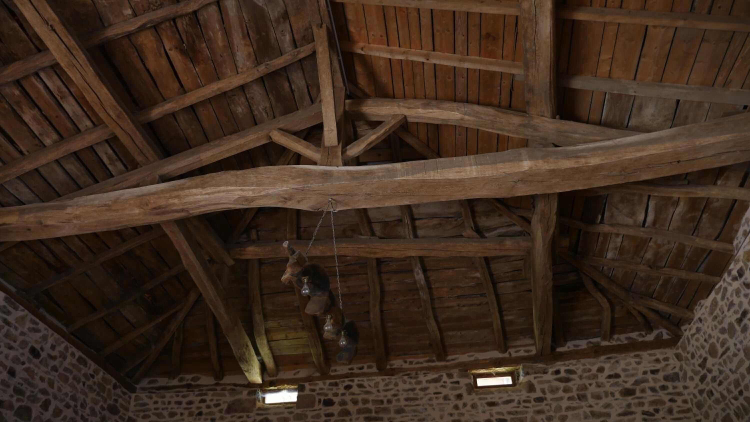 A rustic interior with exposed wooden beams and stone walls.
