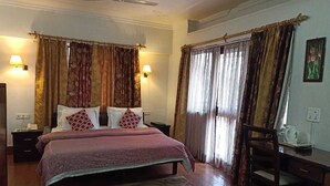 A bedroom with a bed, a desk, and a chair. - Dragon I Resorts (Dharamshala)