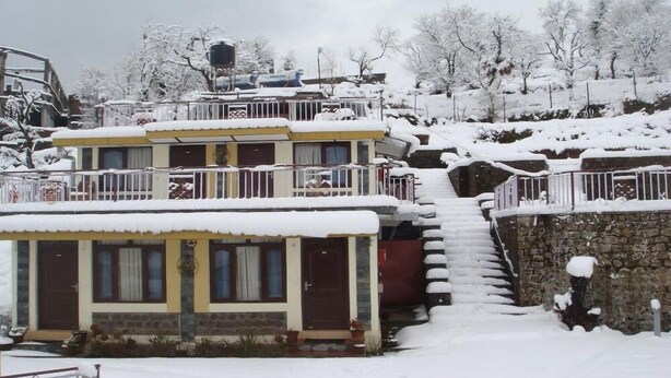 A multi-story building with a snow-covered exterior and a staircase leading to the upper levels. - Dragon I Resorts (Dharamshala)
