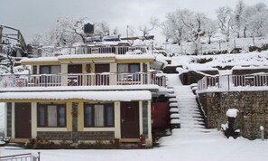 A multi-story building with a snow-covered exterior and a staircase leading to the upper levels. - Dragon I Resorts (Dharamshala)