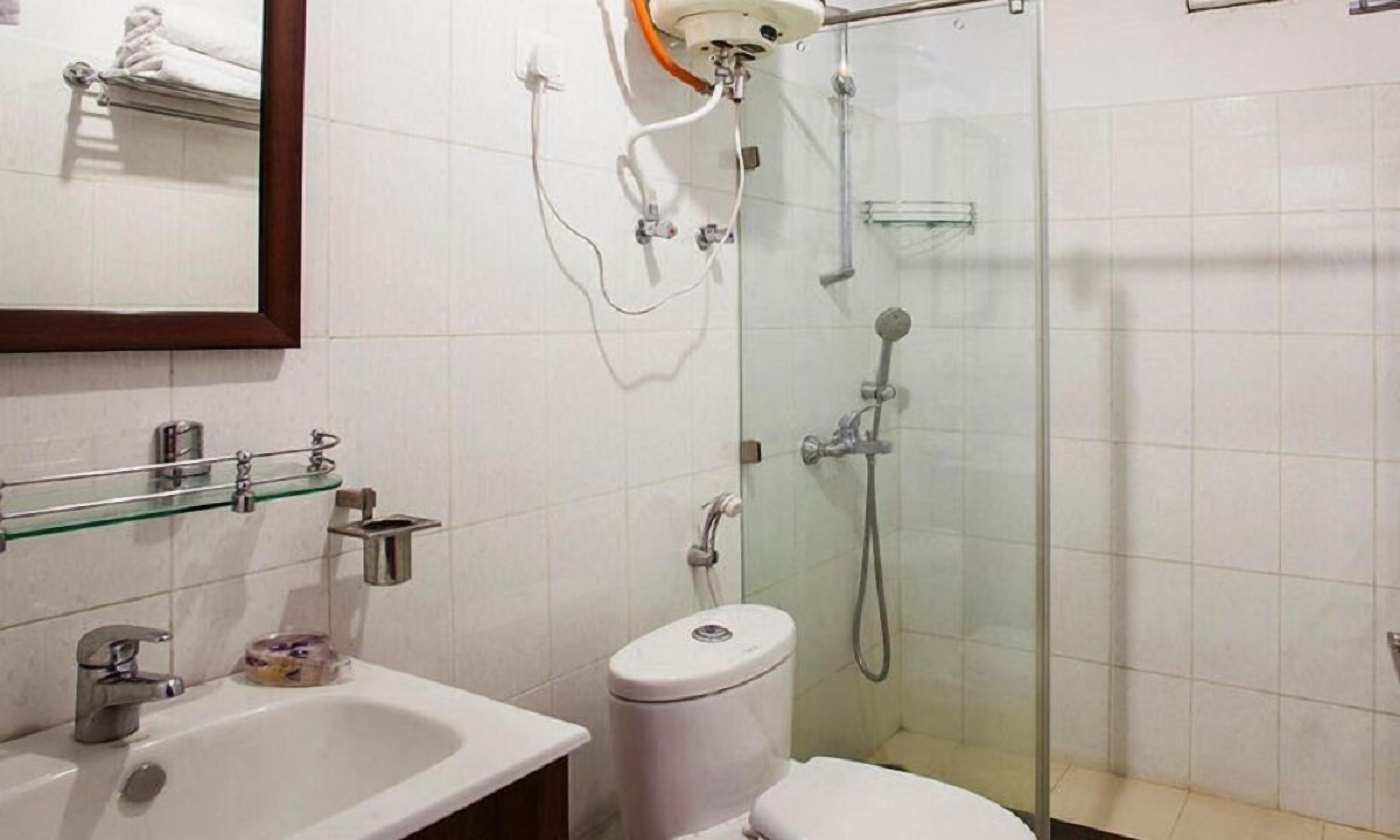 Un baño con ducha de vidrio, lavabo blanco y un inodoro.