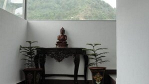 A corner of a room with a small table and two potted plants. - Dragon I Resorts (Dharamshala)