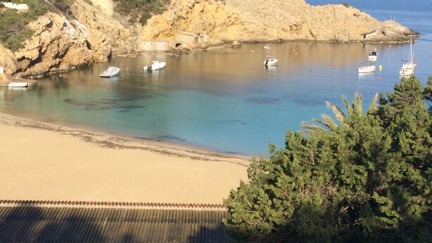 A coastal scene with boats, a sandy beach, and rocky cliffs. - Charming villa with sea view- next to the beach-Ideal for couples and families (Cala -Vadella)