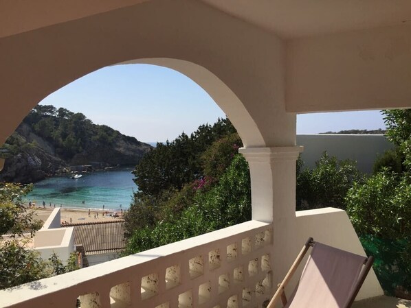 A balcony with a view of a coastal area, including a beach and rocky cliffs. - Charming villa with sea view- next to the beach-Ideal for couples and families (Cala -Vadella)