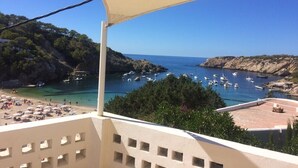 A coastal view with a beach, boats, and rocky cliffs. - Charming villa with sea view- next to the beach-Ideal for couples and families (Cala -Vadella)