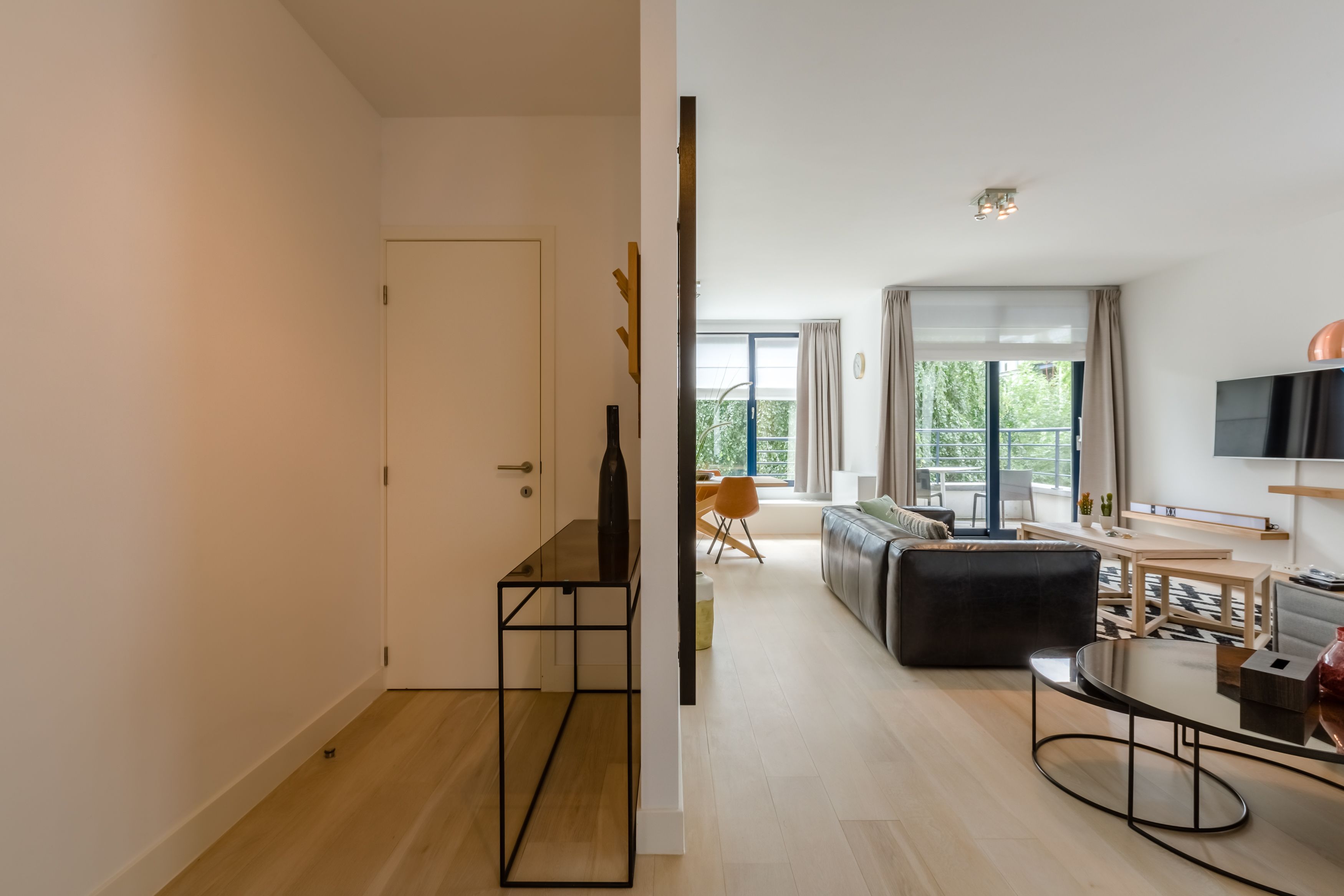 Un salon moderne avec un canapé, une table basse et un téléviseur.