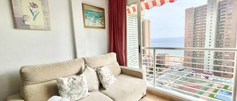 A balcony with a view of high-rise buildings and a pool.