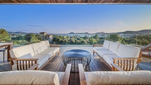 An outdoor deck with wooden furniture and a view of the landscape.