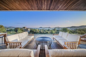 An outdoor deck with wooden furniture and a view of the landscape.