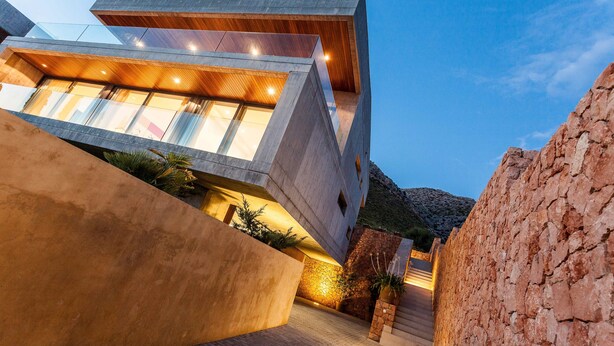 A modern building with a unique angular design, large windows, and a well-lit interior.