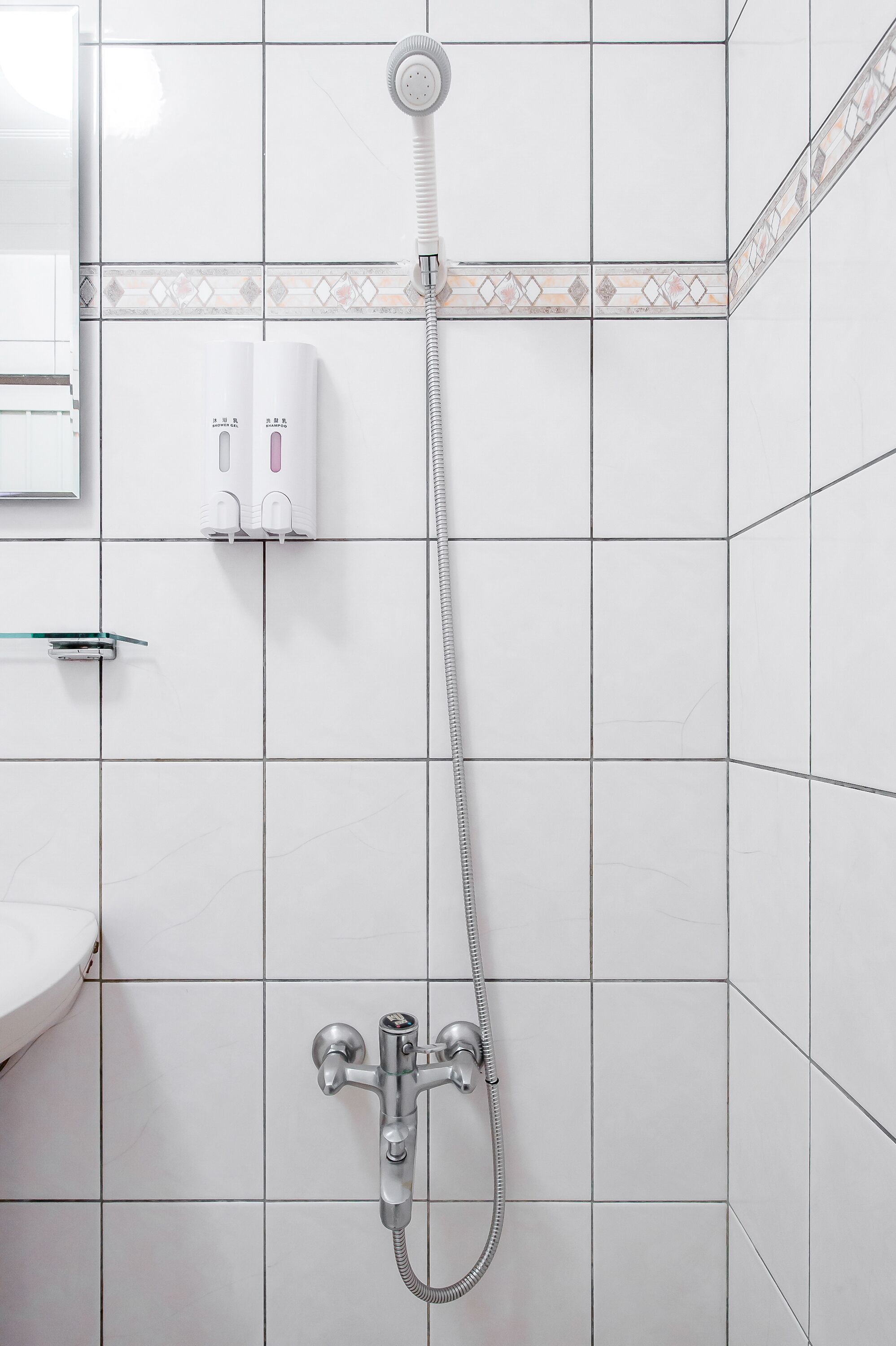 A bathroom with a shower, a toilet, and a sink.
