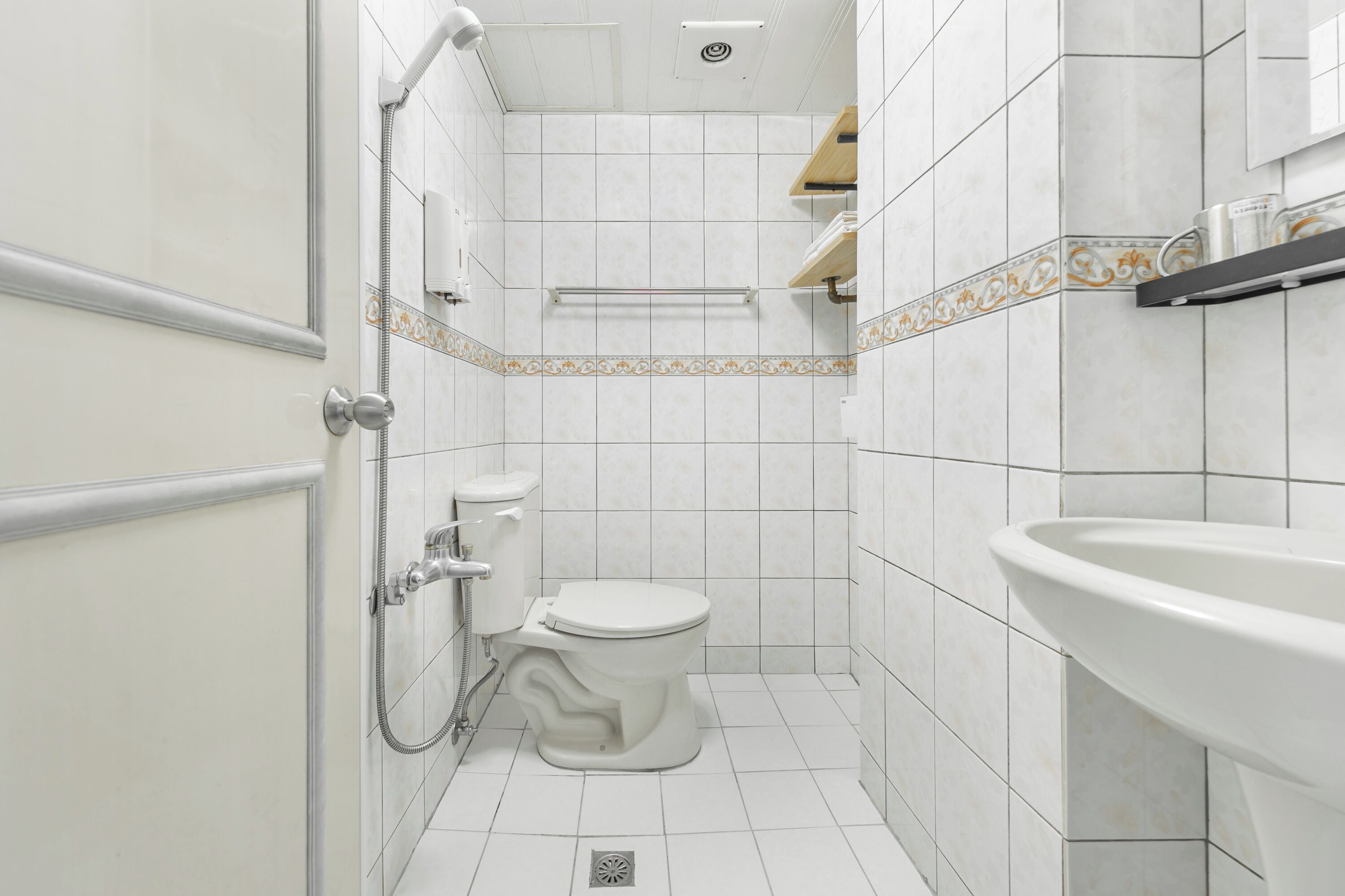 A bathroom with a toilet, shower, and sink.