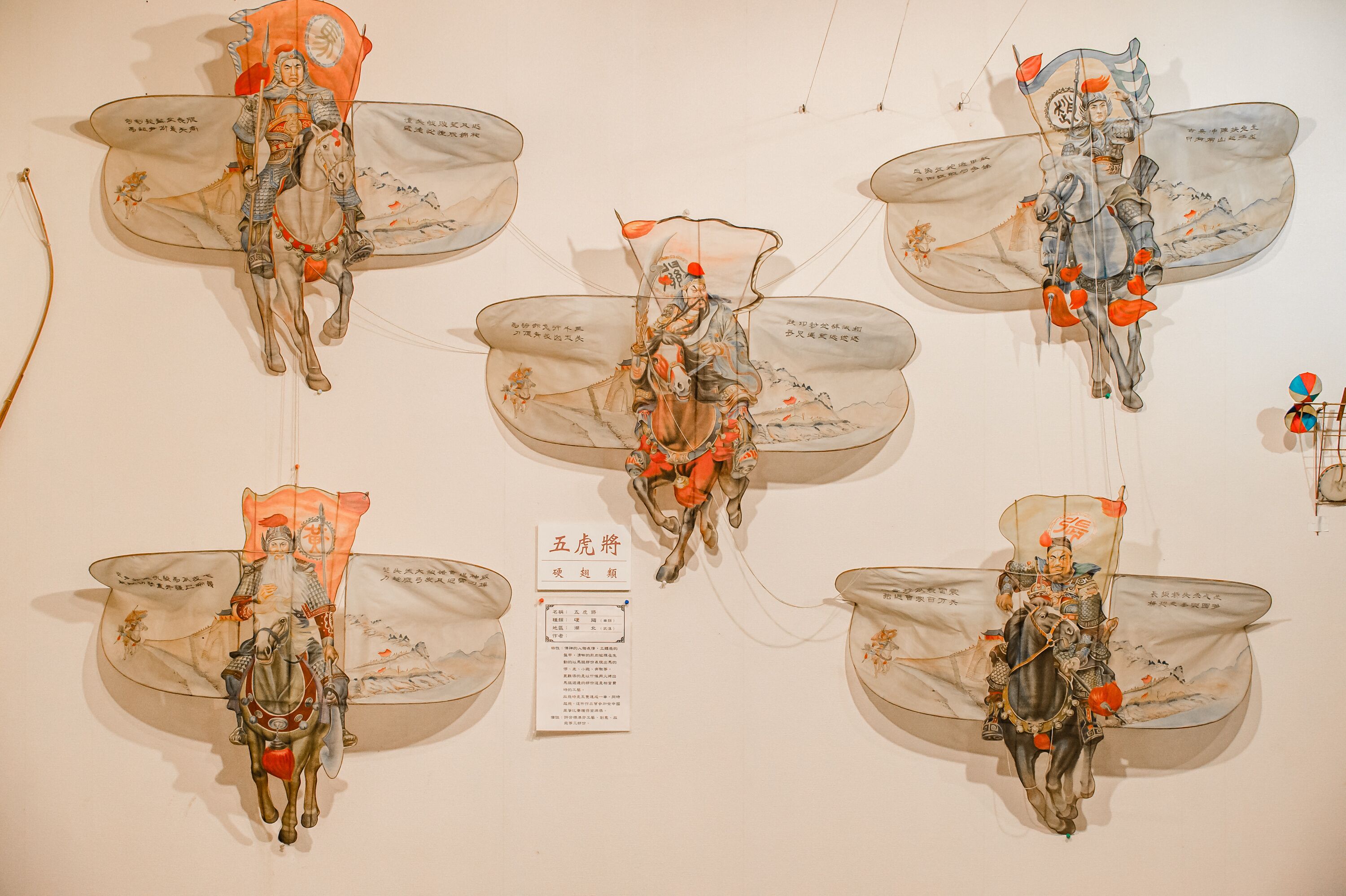 A wall with multiple mounted artworks depicting historical figures on horseback.