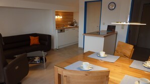 Un espacio habitable moderno con comedor, cocina y sofá.
