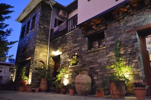 Un edificio de piedra con balcón y plantas en macetas.