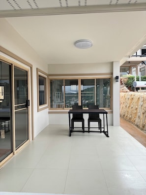 A spacious room with large windows, a table with chairs, and a view of the cityscape.
