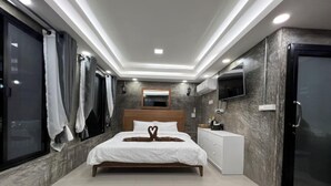 A modern bedroom with a bed, bedside table, TV, and a wardrobe. - Mon Ing Dao (Mae Rim)