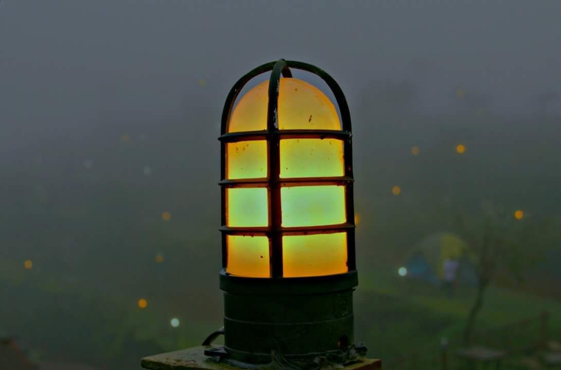 A lantern with a grid pattern, mounted on a post.